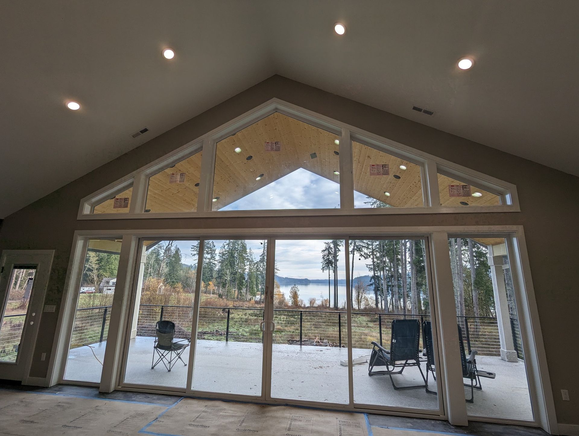 A large room with a lot of windows and a view of a lake.