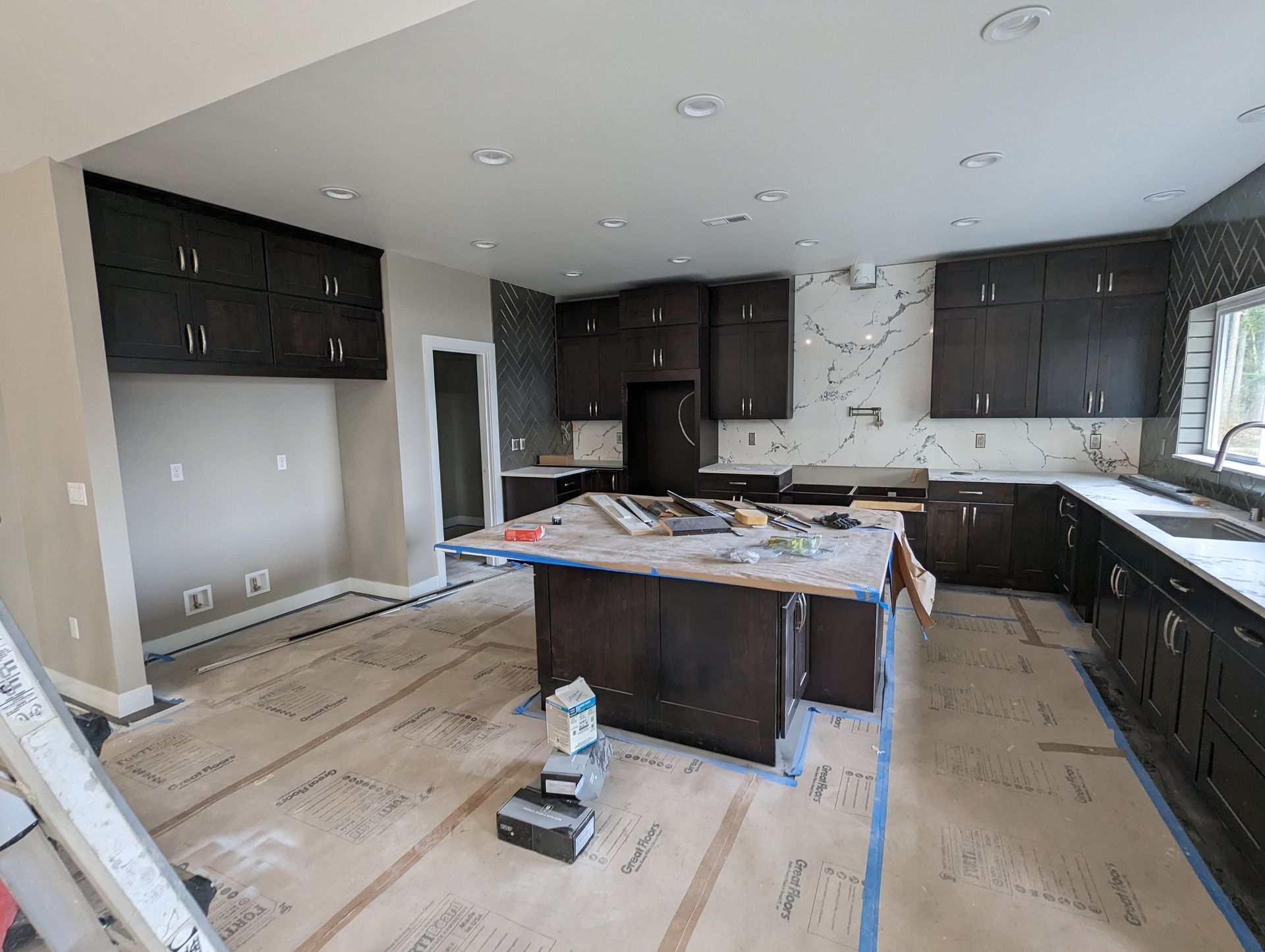 A kitchen under construction with a large island in the middle.