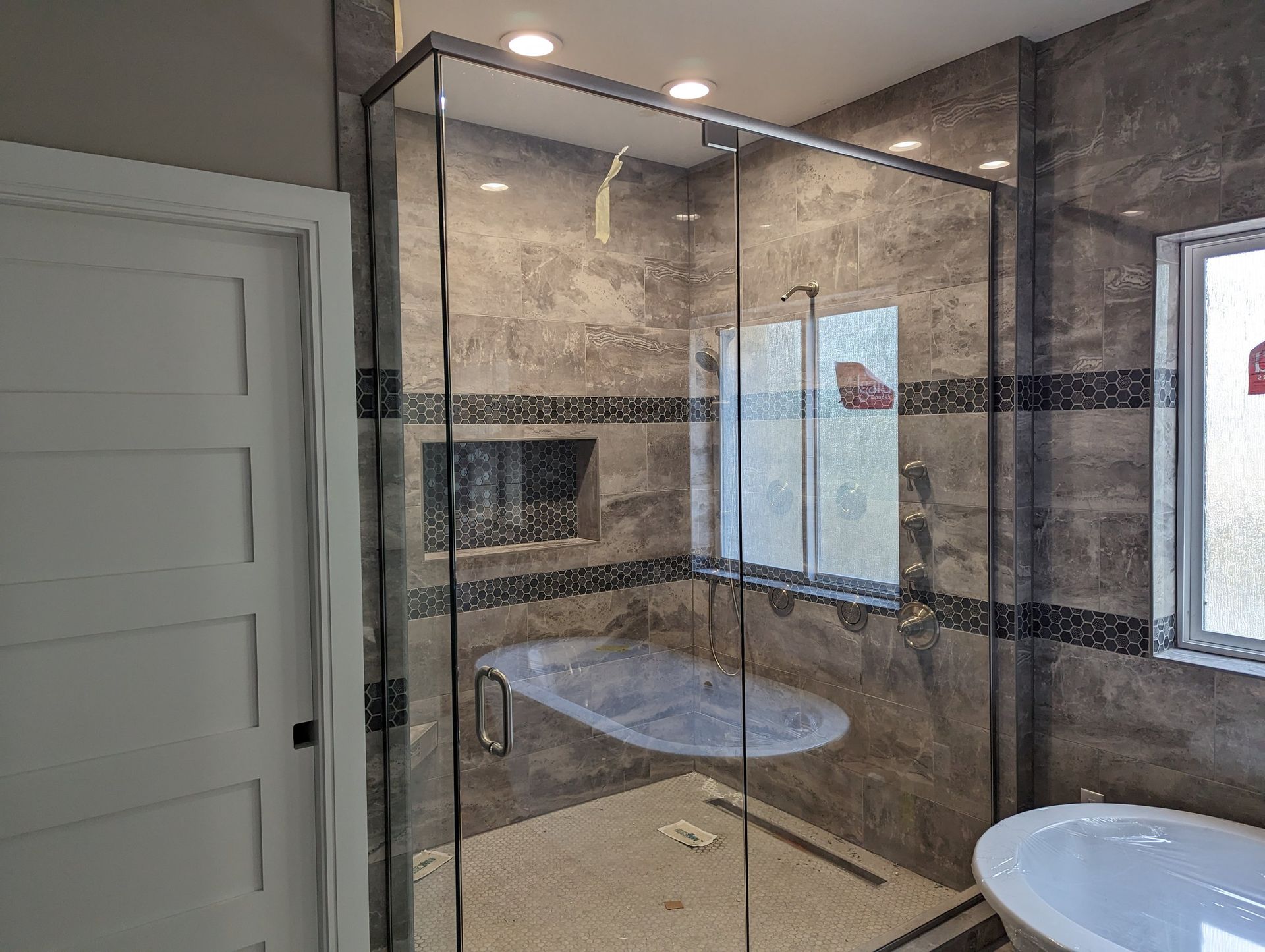 A bathroom with a walk in shower and a bathtub.