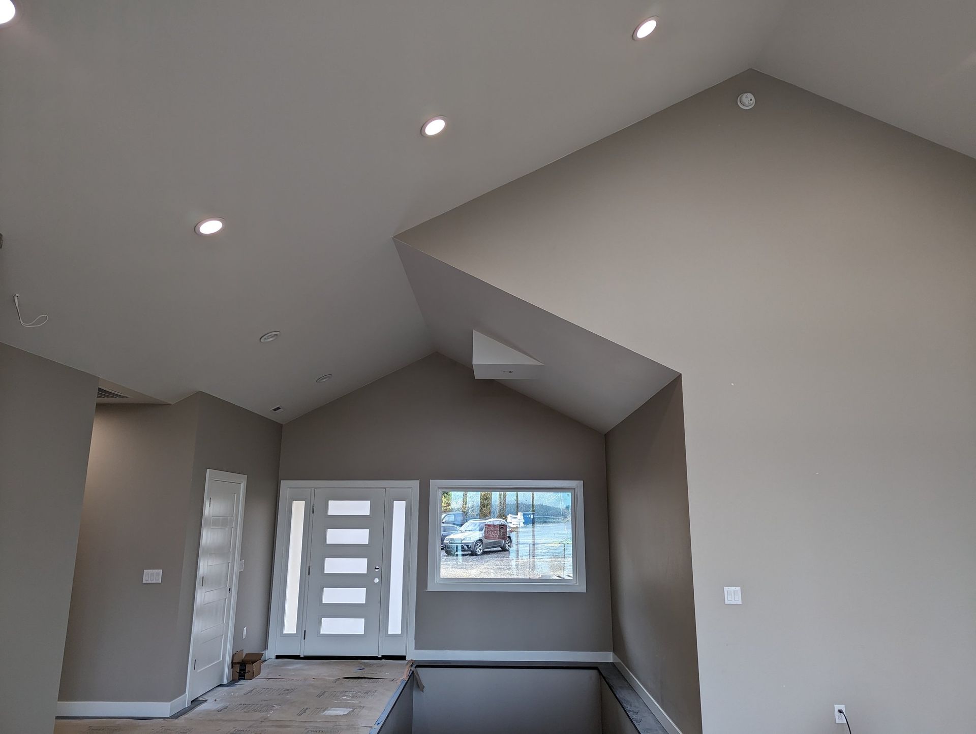 A living room with a vaulted ceiling and a window.