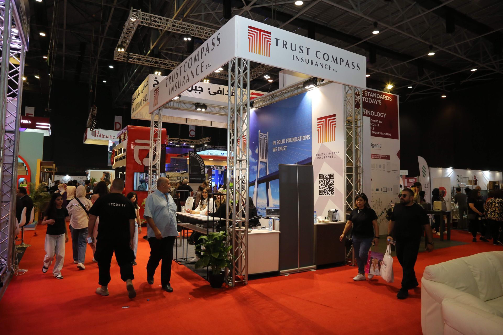 People walk past a trade show booth with the