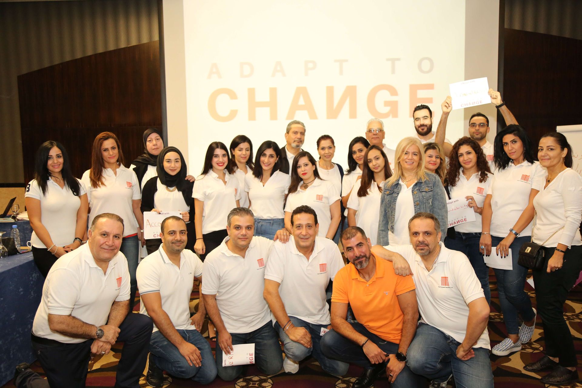 Group of people in white shirts pose for a photo with 