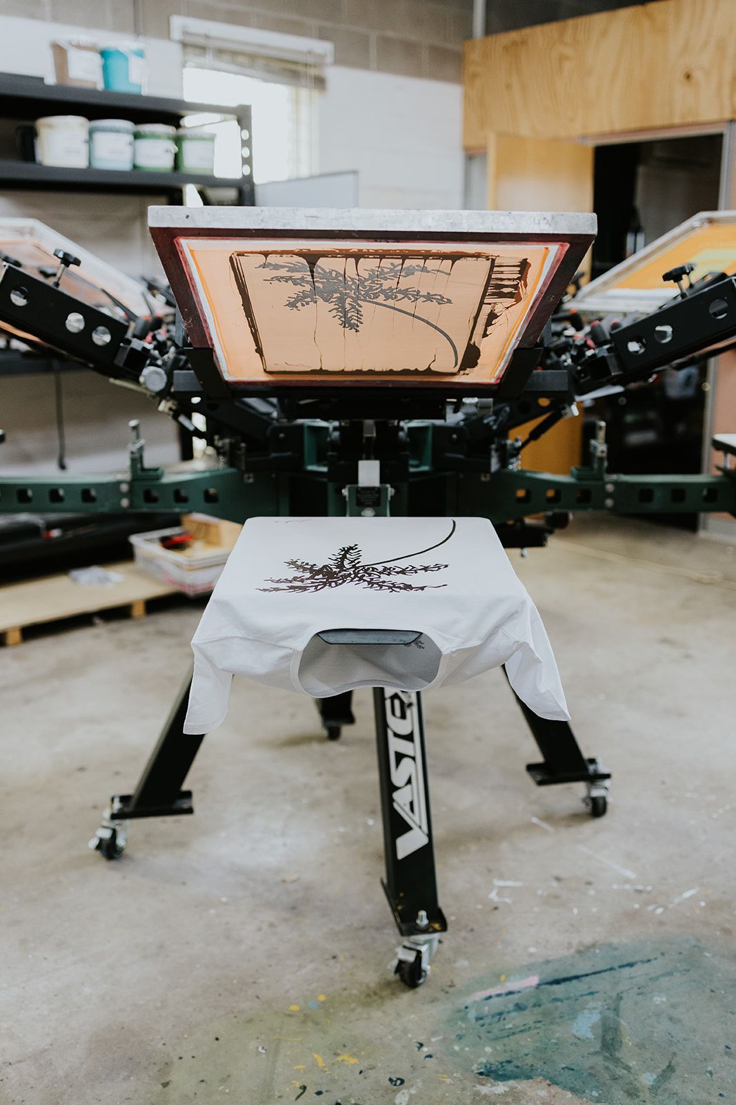 A Machine Is Printing a Piece of Paper with Red Ink — CKM Screen Printing in West Gosford, NSW