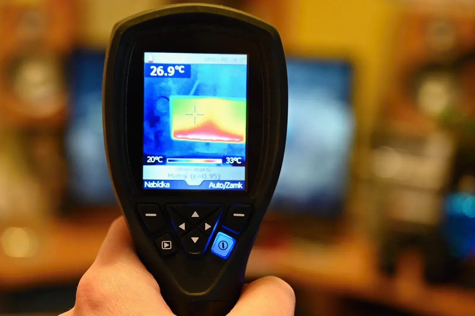 A person is holding a thermal camera in their hand.