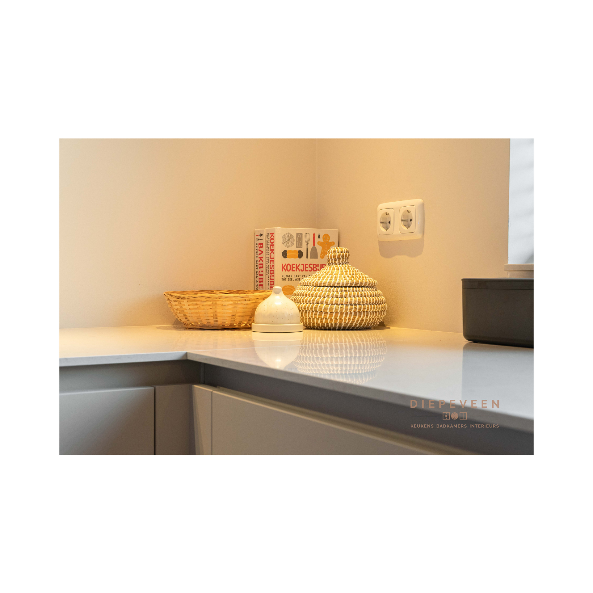 Een aanrecht met daarop een mand en een kom.