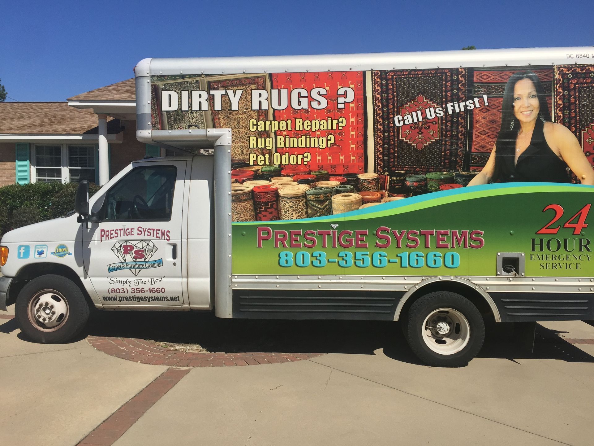 White Prestige Systems rug cleaning truck, parked in a driveway, advertising