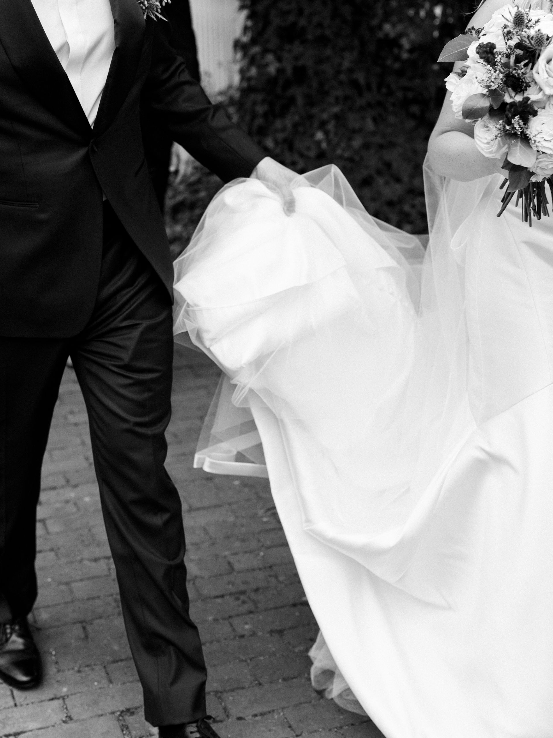 couple holding dress and walking
