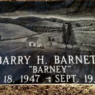 A gravestone for barry h. barney with a black and white photo of a farm.