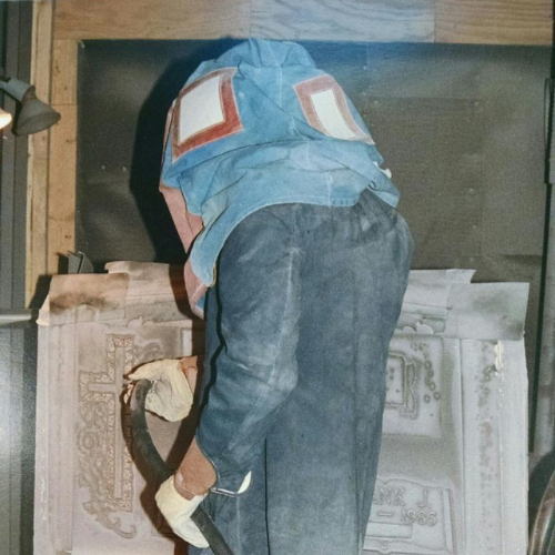 A man in a blue shirt is using a vacuum cleaner