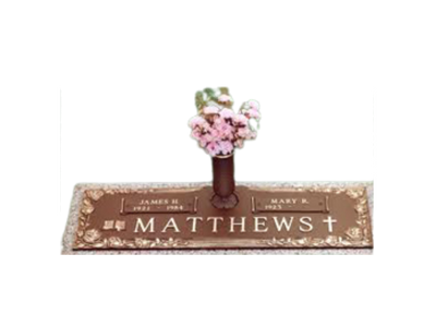 A gravestone with a vase of flowers on top of it.