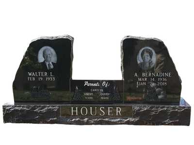 A black gravestone with two pictures of a man and a woman on it.