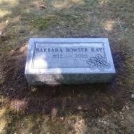 A gravestone for barbara bowser ray is sitting in the grass in a cemetery.