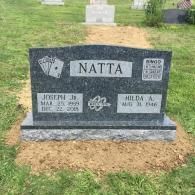 A gravestone in a cemetery with a playing card on it.