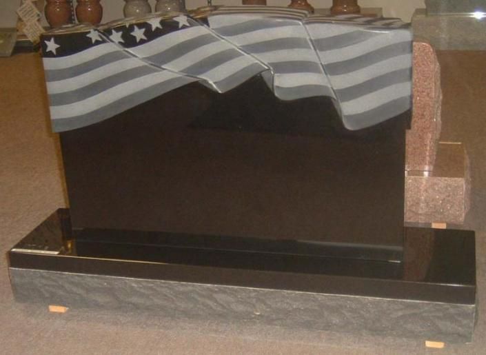 A black gravestone with an american flag on it