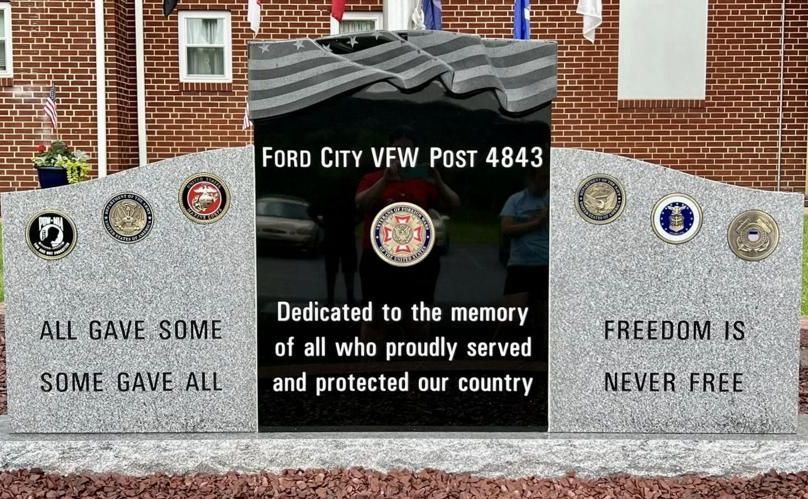 A ford city veterans memorial with a brick building in the background