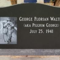 A black gravestone with a picture of a man on it.
