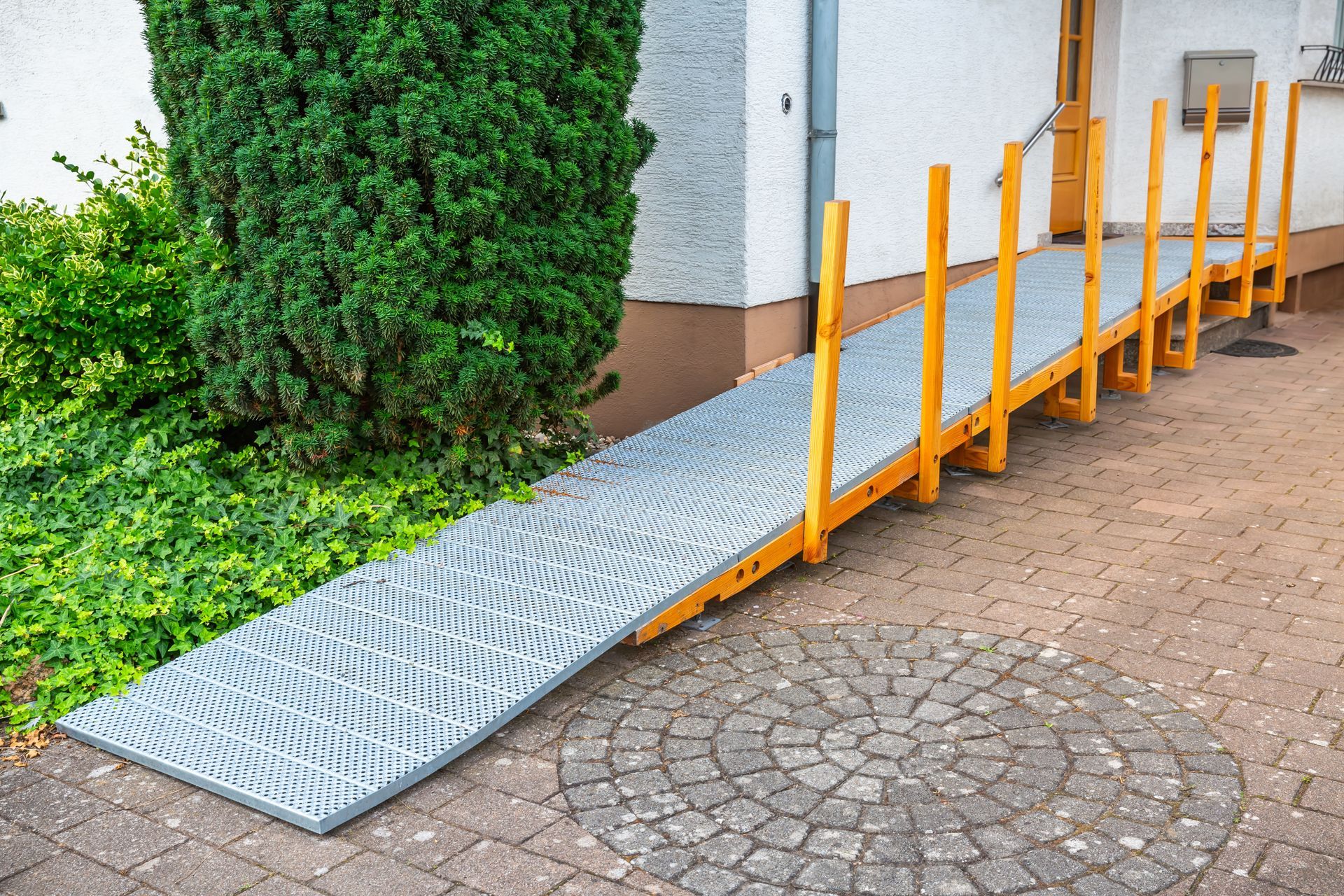 A ramp is sitting on the sidewalk in front of a house.