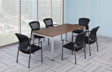 A conference room with a table and chairs in front of a window.