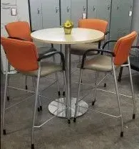 A table and chairs in a room with lockers in the background.
