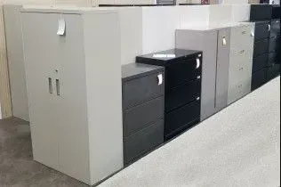 A row of filing cabinets and drawers are lined up in a room.