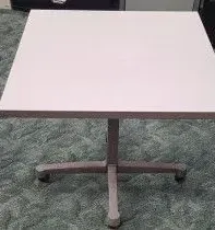 A white table is sitting on top of a green carpet.