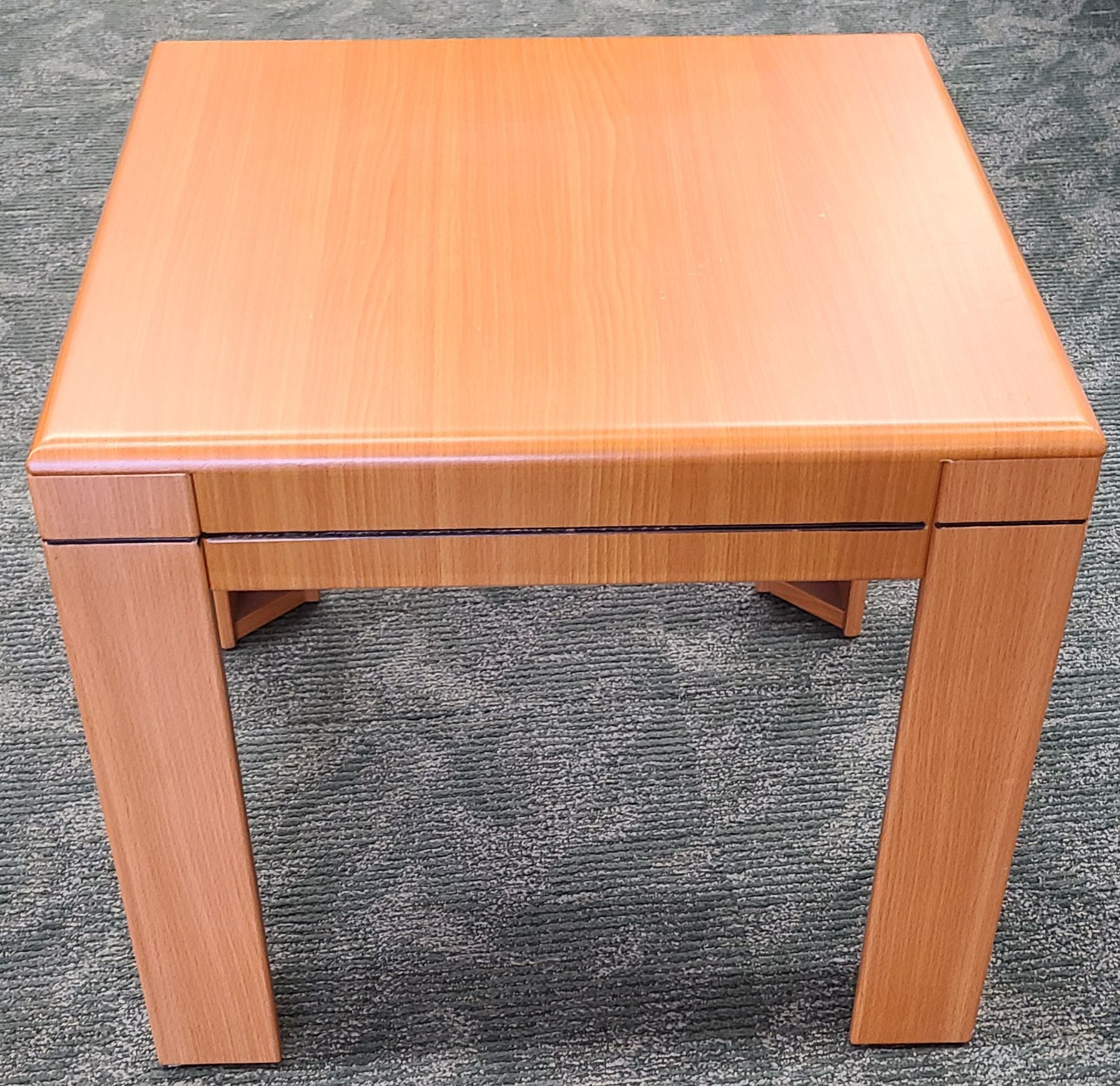 A small wooden table is sitting on a carpet