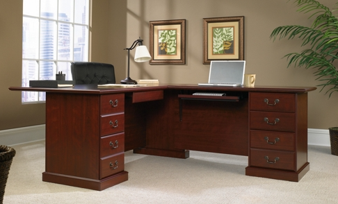 A wooden desk with drawers and a laptop on it