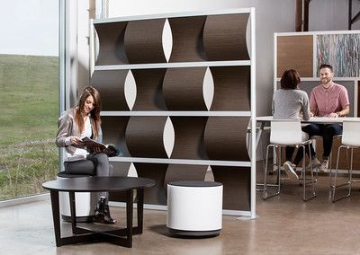 A woman is sitting at a table reading a book in a room.