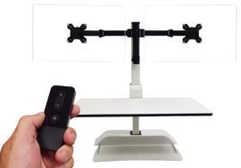 A person is holding a remote control in front of a monitor mount.