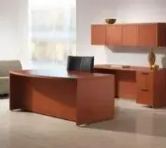 There is a large wooden desk in the middle of the room.