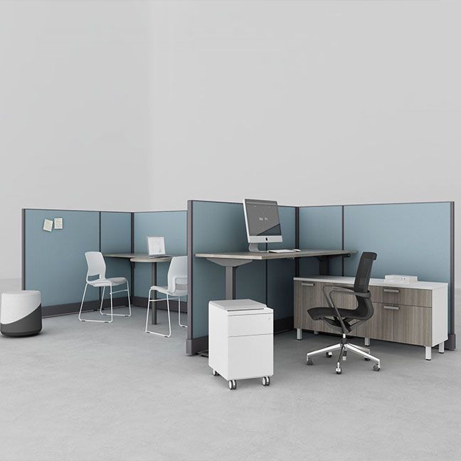 A computer is on a desk in a cubicle