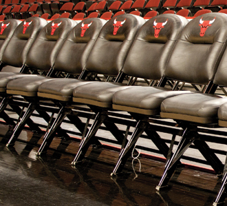 A row of black chairs with red bulls on them