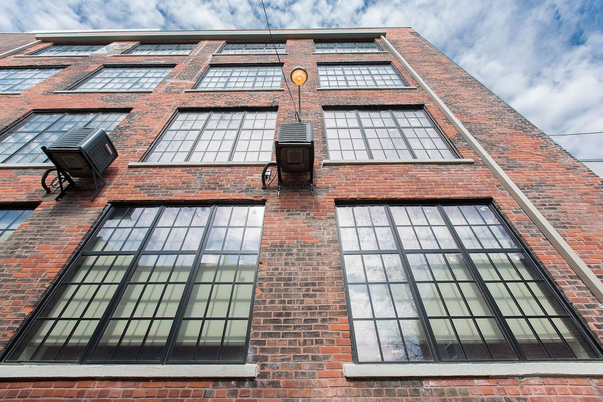 Looking up at a brick building with lots of windows.