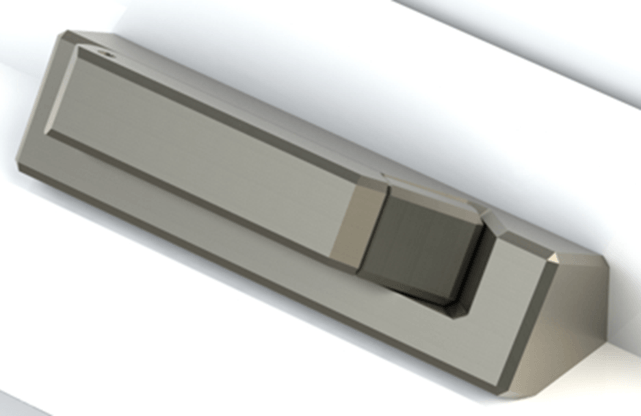 Angled, metallic gray electronic device on a white surface, featuring a raised section with a darker gray square.