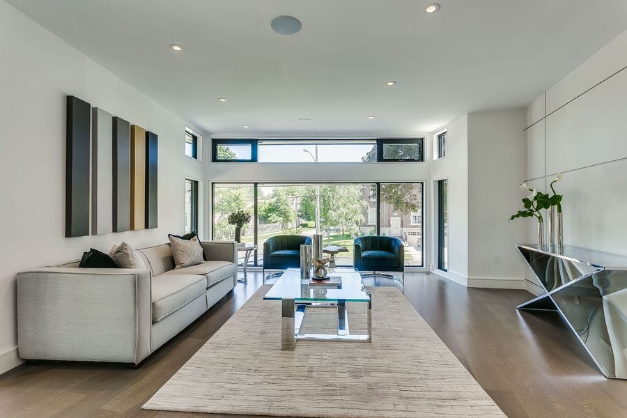 A living room with a couch , chairs , coffee table and rug.