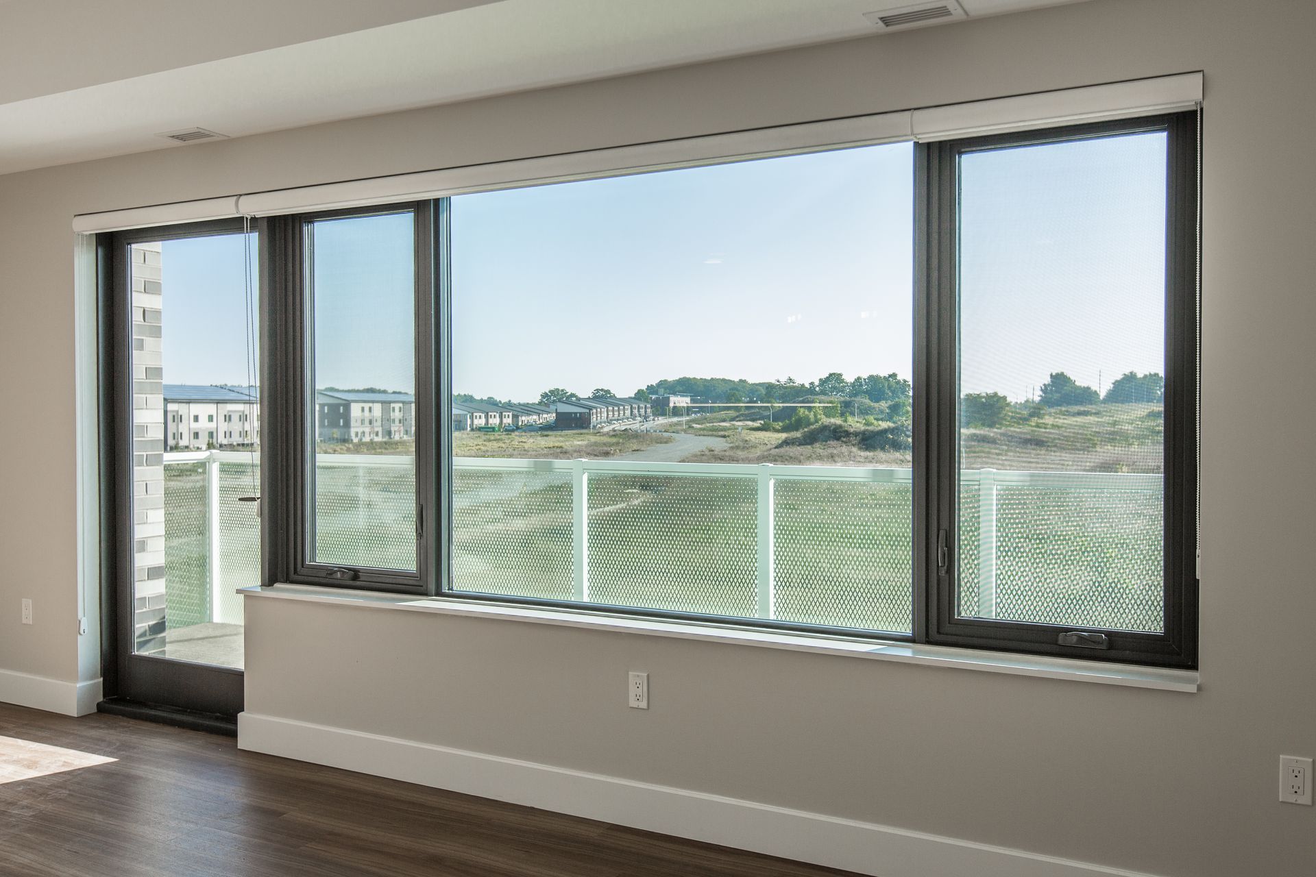 A living room with a couch , coffee table , and lots of windows.