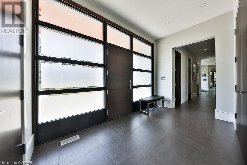 A hallway in a house with a bench and lots of windows