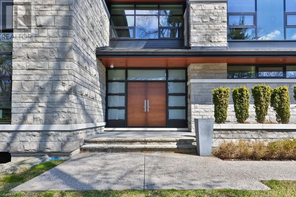 The front of a large house with a wooden door and stairs.