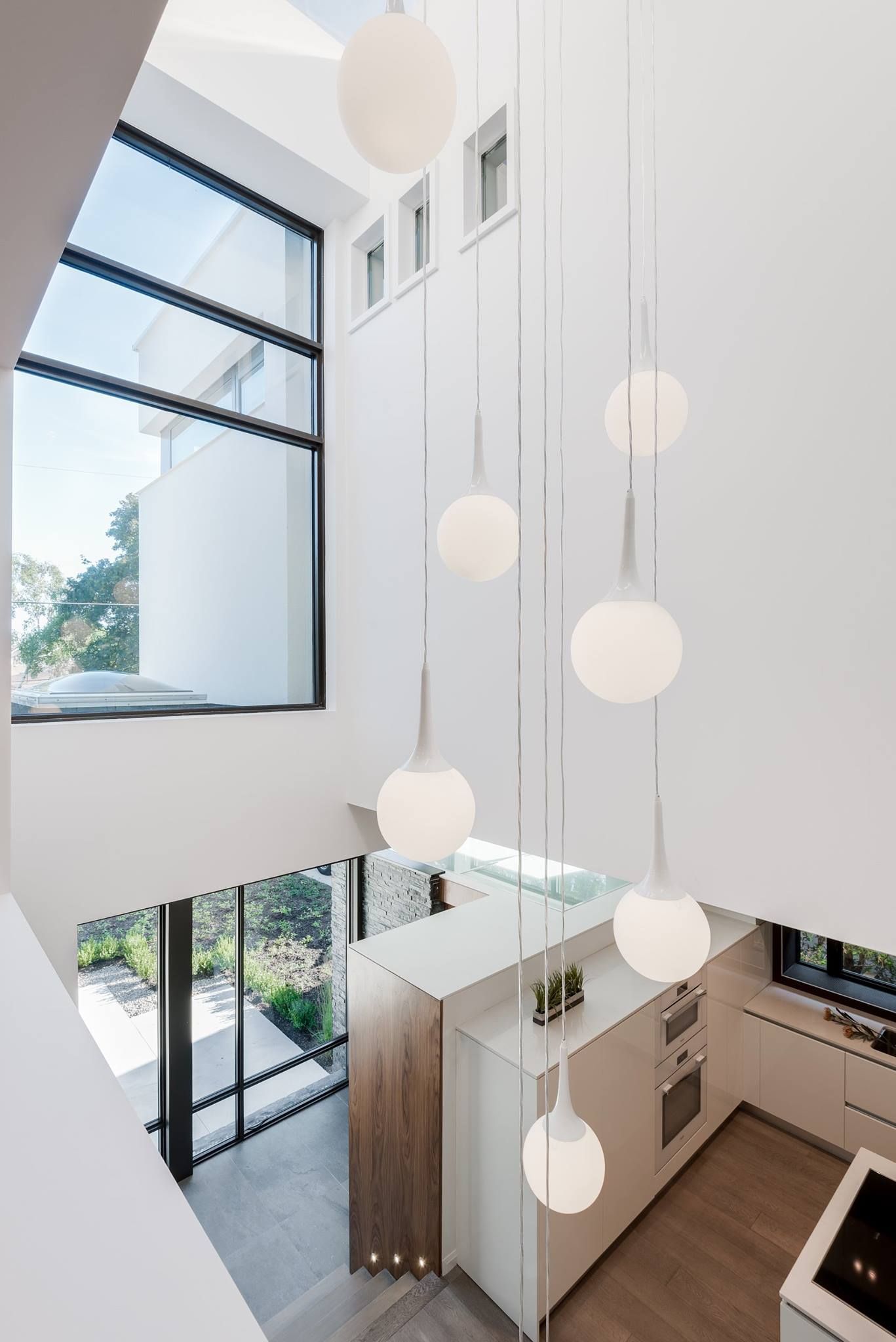 A kitchen with a lot of windows and lights hanging from the ceiling