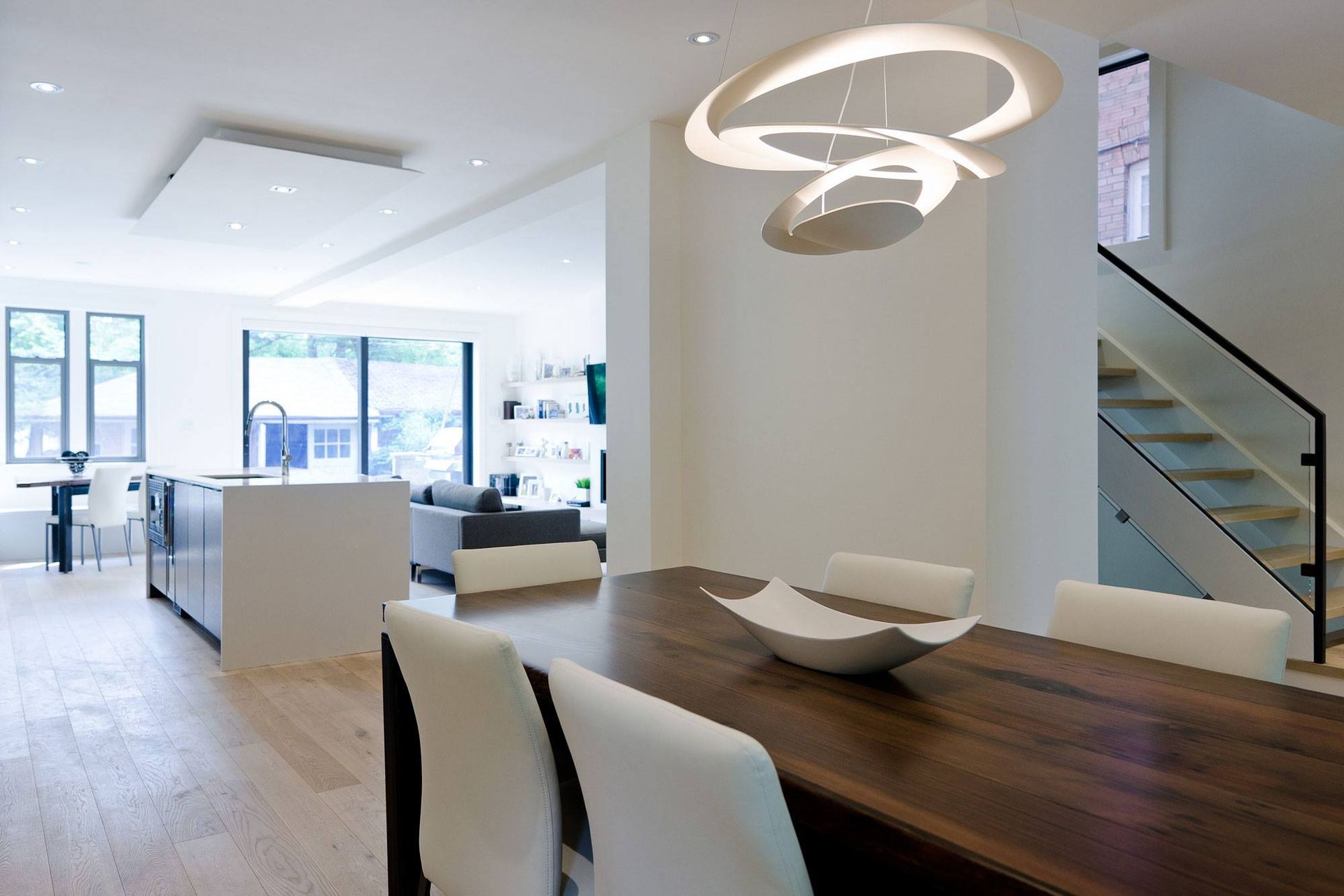 A dining room with a wooden table and white chairs