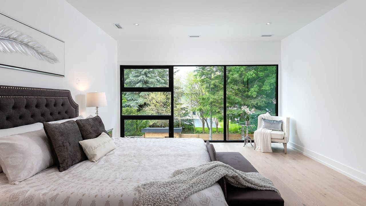 A bedroom with a large bed and a large window.