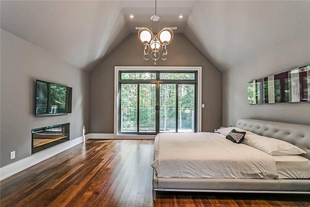 A large bedroom with a king size bed and hardwood floors