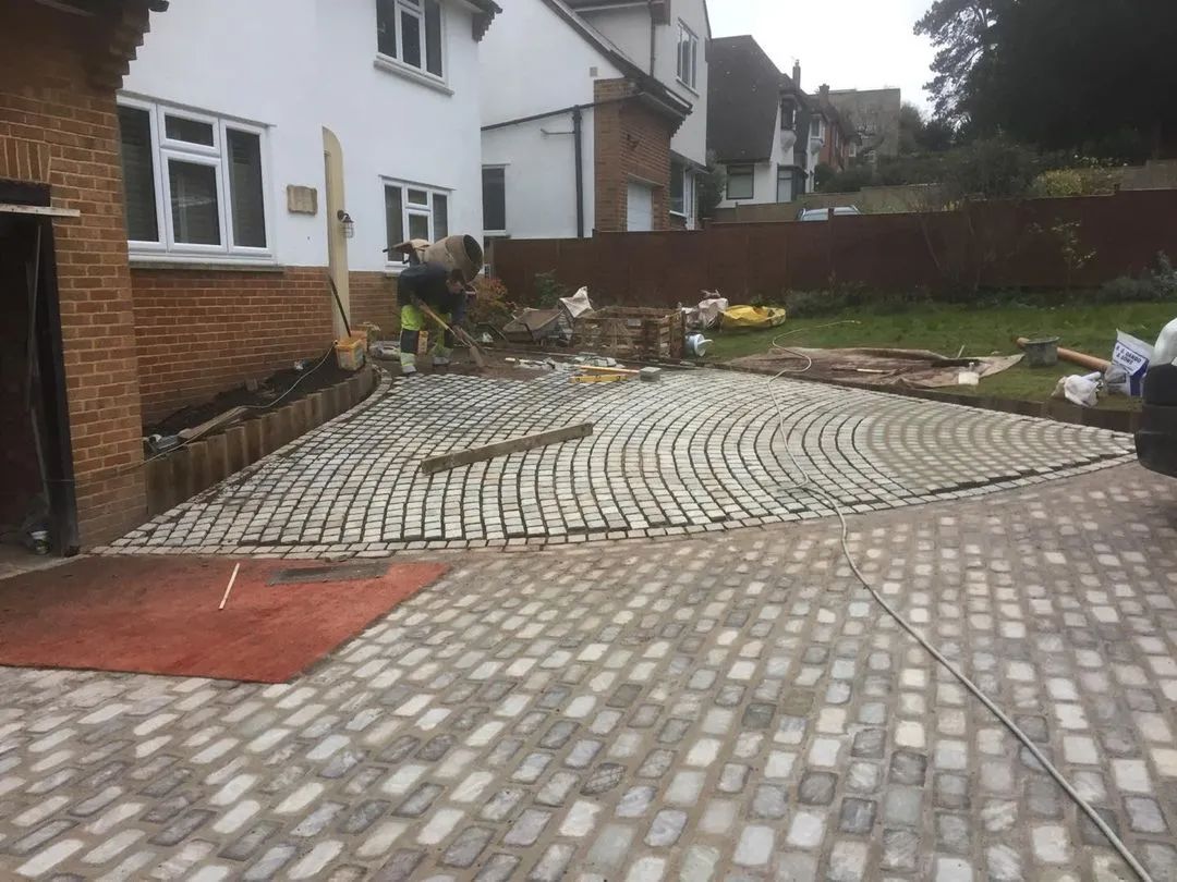 Urban Paving Bristol | A brick driveway is being built in front of a house.