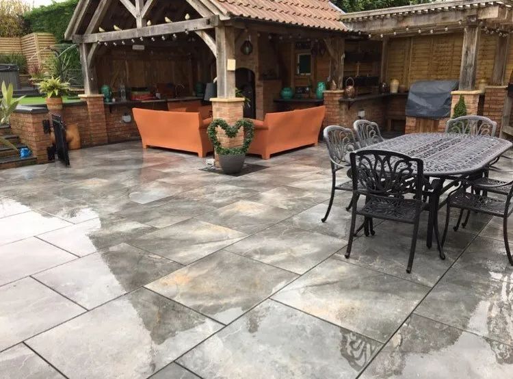 Urban Paving Bristol | A patio with a table and chairs and a gazebo in the background.