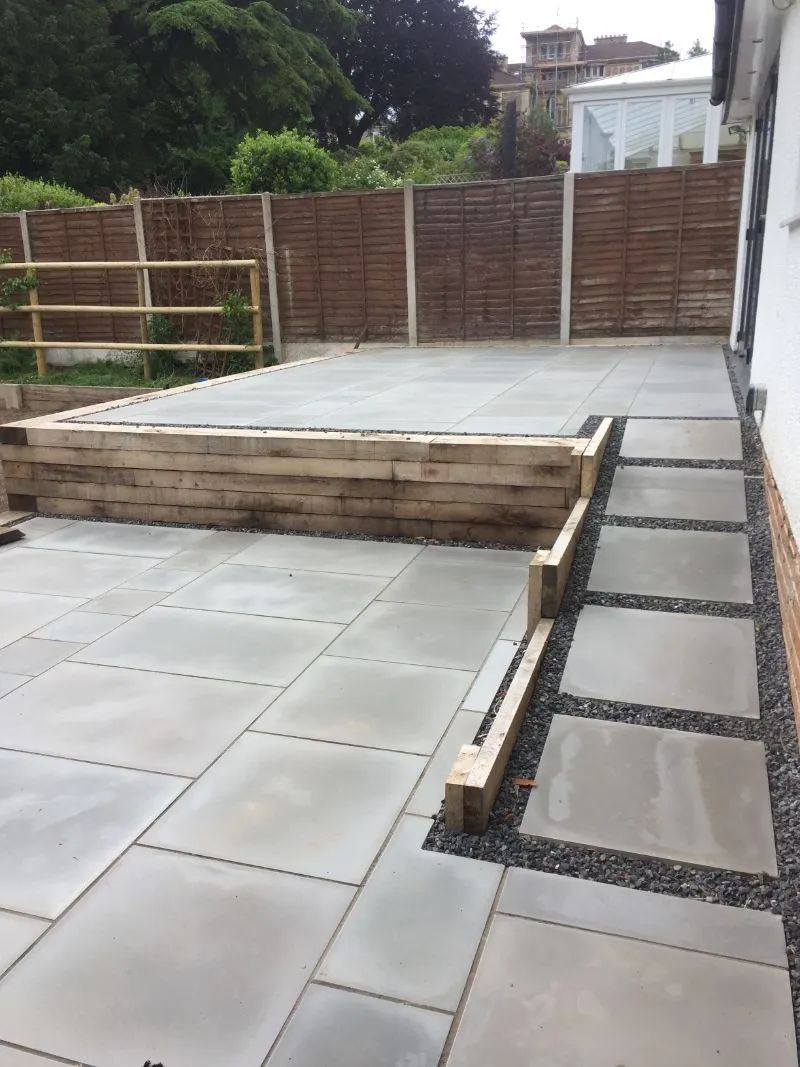 Urban Paving Bristol | A concrete patio with a wooden fence in the background.