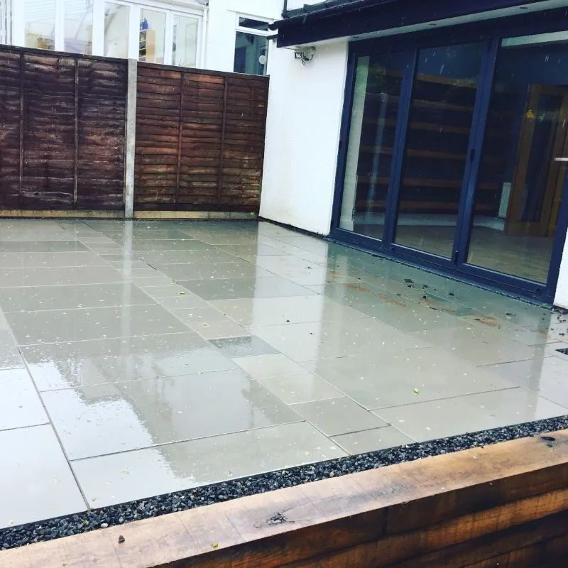 Urban Paving Bristol | A patio with a wooden fence and sliding glass doors