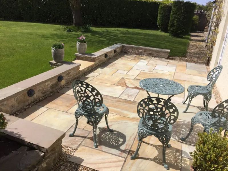 Urban Paving Bristol | A patio with a table and chairs in a garden.