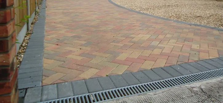 Urban Paving Bristol | A brick driveway with a drain on the side of it.