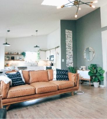 a living room with a brown couch and a mirror