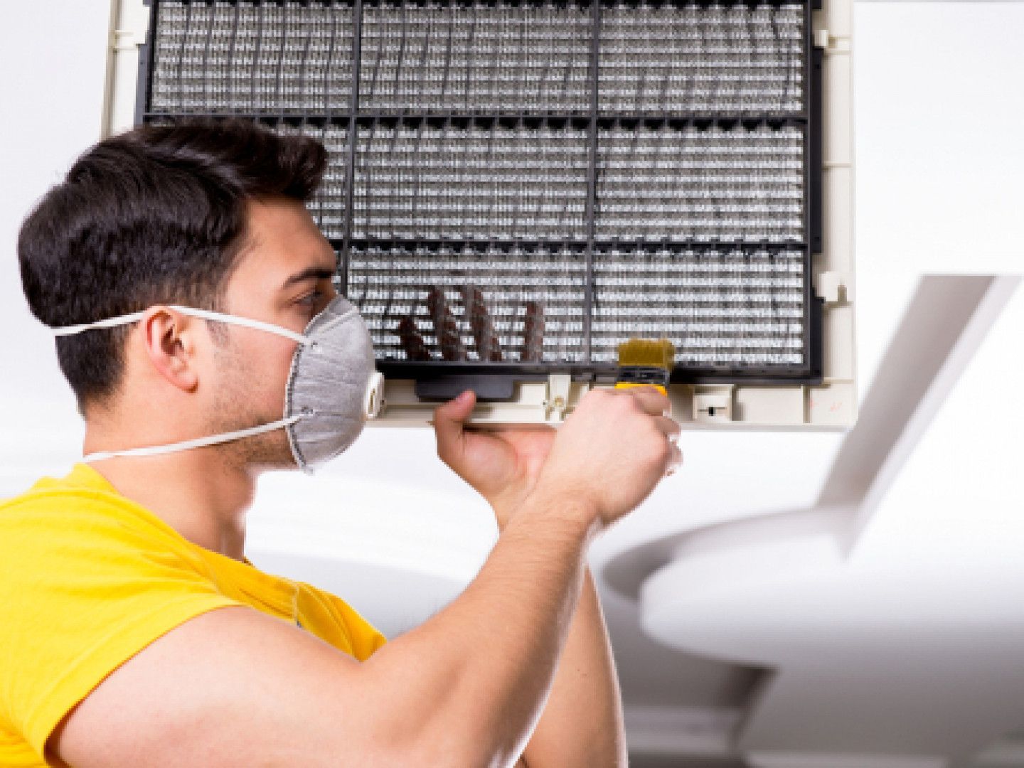 Woman in straw hat smiles, holding wine glass near a lake.